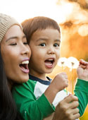 Child and mother blowing dandelion fuzz